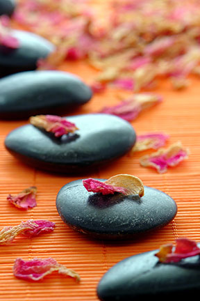 Flower petals and polished stones on mat